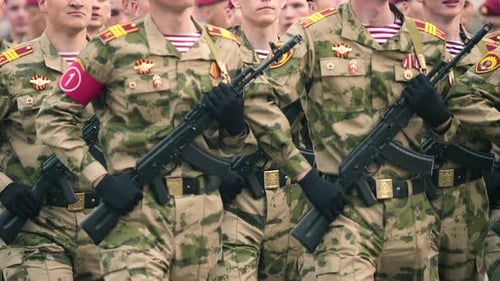 Soldiers Marching in Camouflage Uniforms with Weapons
