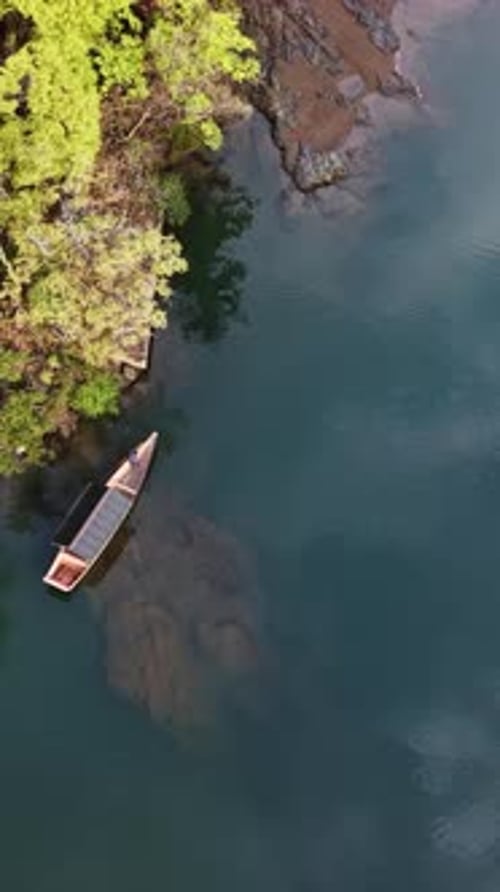 Drohnenaufnahme eines Bootes, das sich auf dem Katsura-Fluss in Arashiyama, Japan, bei Tageslicht bewegt