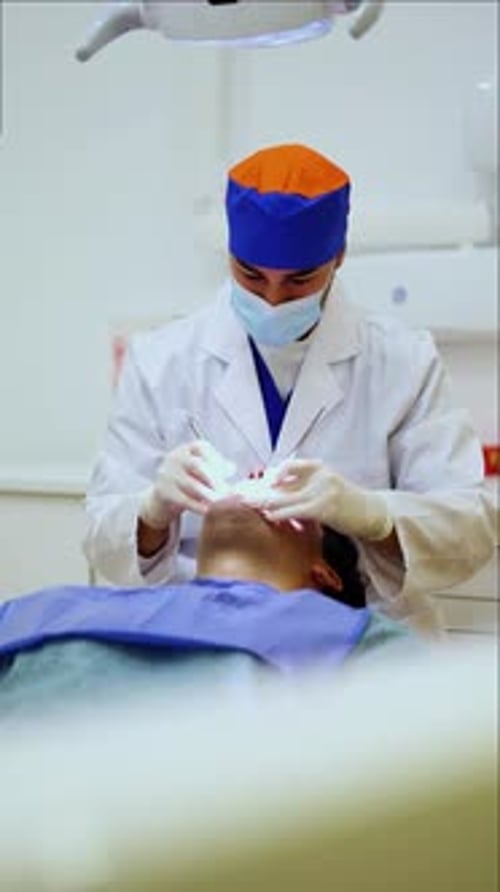 vertical Dentist examining patient's teeth in dental clinic