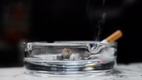 a cigarette is placed in an ashtray