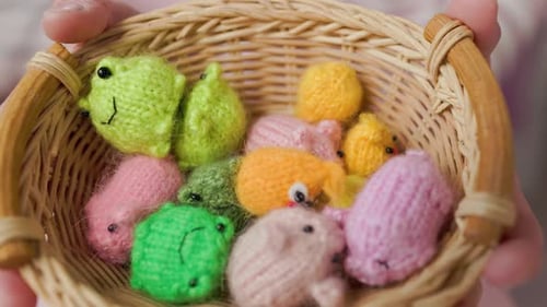 Mädchen spielt mit kleinen gestrickten Tierspielzeugen in einem Zimmer zu Hause