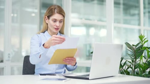 Business Woman Opens Envelope and Reacts to Good News