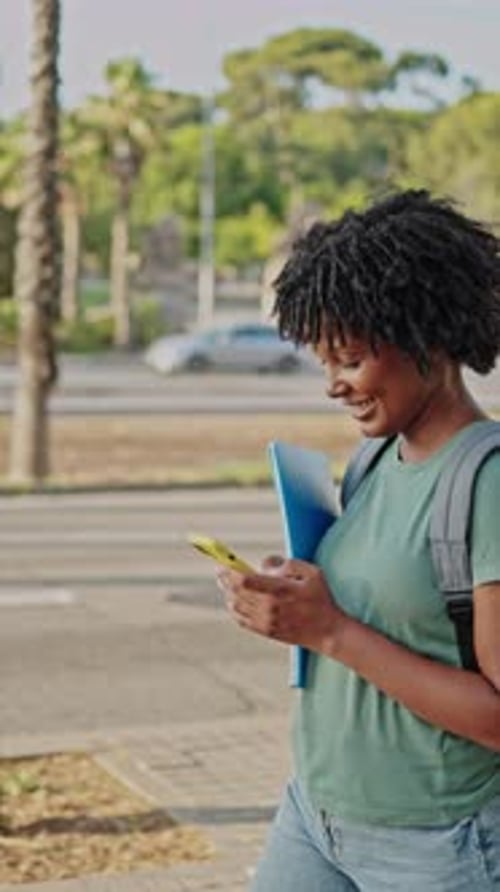 Smiling Woman Walks Down Urban Sidewalk