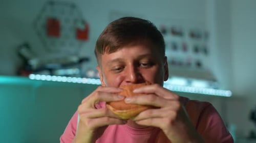 Young Man Eating a Burger Close Up