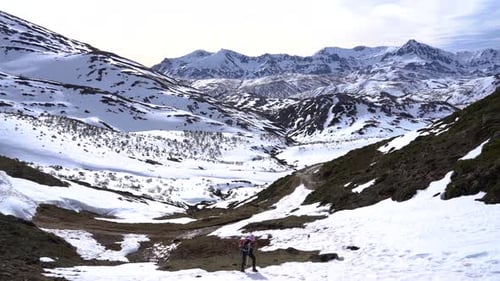 Woman trekking and climbing an snowed hill.