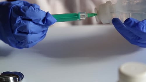 Medical Professional Drawing Liquid into Syringe