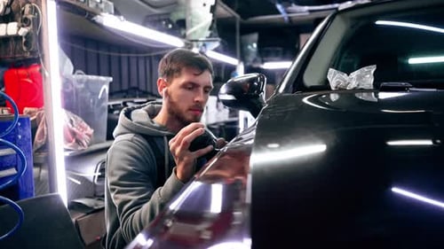 the Car Mechanic at a Service Station Doing the Final Polishing to Shine