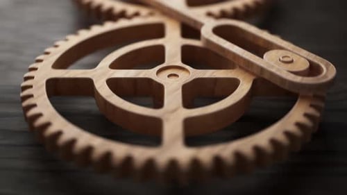 Looping animation of two wooden gears connected by a mechanical shaft.
