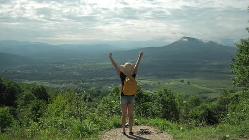Woman on Top of Mountain with Arms Raised Looking at View Hiker Enjoy Trip