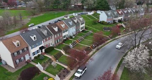 Colorful townhouse homes in USA. American residential town. Truck drives on road. Aerial establishin