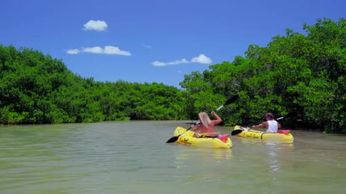 Couple kayaking turquoise waters off tropical bahamas island paradise