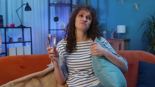 Sad Woman Drinking Wine on Couch at Night