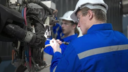 Both of engineers working together in a robotic arm factory,