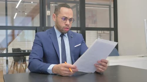 Businessman Reacts to Bad News at Office Desk