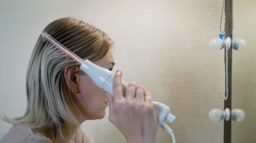 Woman Uses Hair Care Device on Her Scalp