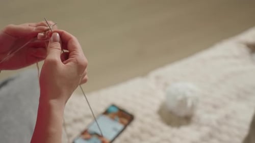 Woman's Hands Knitting with Beige Yarn Indoors