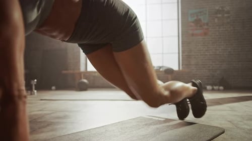 Strong and Fit Athletic Woman in Sport Top and Shorts is Doing Mountain Climber Exercises in a Loft