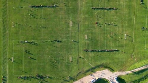 Slow Moving Top Down Aerial View of People Playing on Three Soccer Fields on a Summer Day at Sunset
