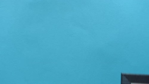 Top View of Hand Putting Empty Frame on Color Background