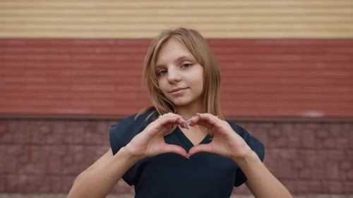 Teen Making Heart Shape with Hands