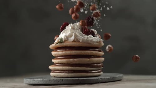 Haselnüsse und Brombeeren fallen in Zeitlupe auf einen Stapel Pfannkuchen. Mit Phantom Flex aufgenommen
...