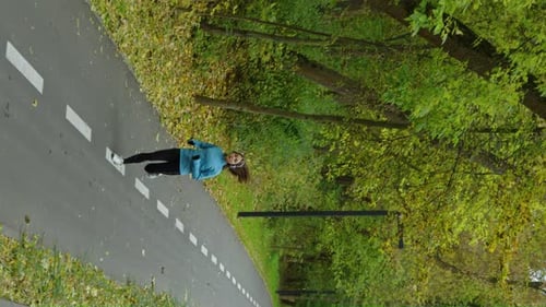 Vertical Screen Young Woman Jogging in Autumn Park in the Morning