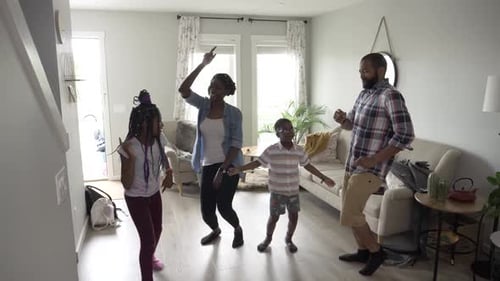 Joyful family dancing in living room