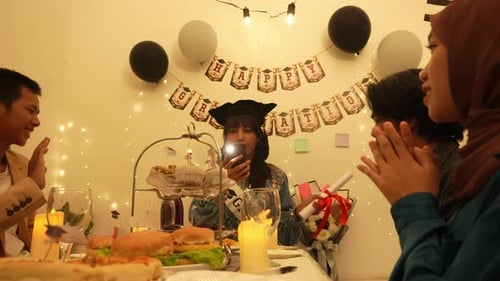 Asian Woman Recording Video In Graduation Party