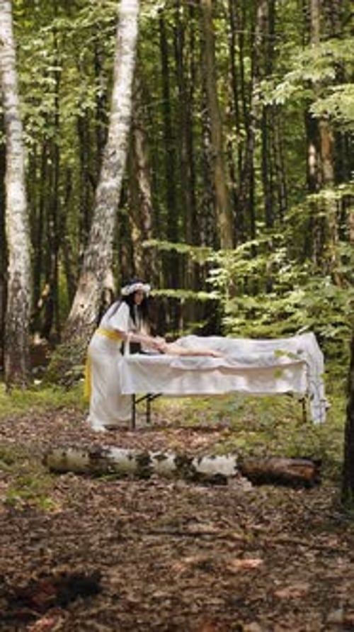Médica terapeuta fazendo massagem facial relaxante no spa com as mãos ao ar livre na floresta