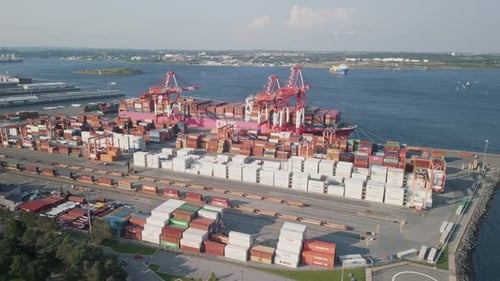 Luftaufnahme eines Handelshafens mit einem beladenen Containerschiff