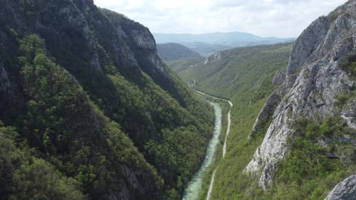 Vista de drone da estrada entre montanhas verdes.