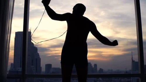 Man silhouette dancing to music in apartment
