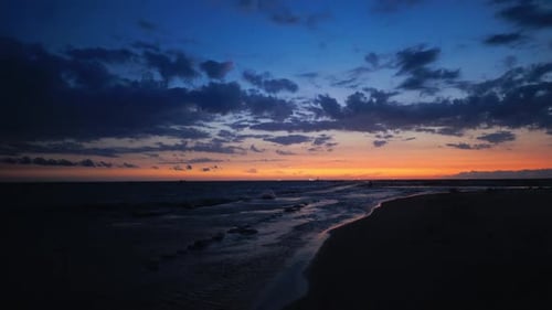 Bewundern Sie den atemberaubenden Sonnenuntergang über den ruhigen Meereswellen, wenn sich die Nacht in der Abenddämmerung nähert — ein perfekter Anblick