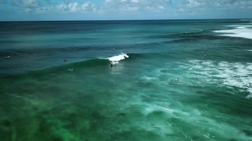 Aerial shot of a surfer riding a large wave on the North Shore Coast of Oahu, Hawaii.
