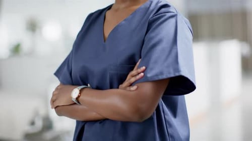 Portrait of happy african american female doctor wearing scrubs in hospital, slow motion