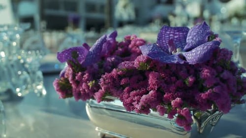 purple flowers on the big dining table. flower and table detail.