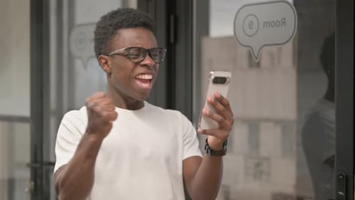 Excited Man Celebrating Good News on Smartphone