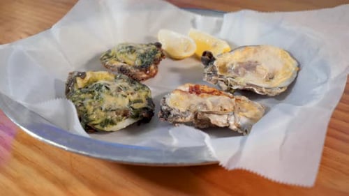 Plate of cooked oysters topped with cheese