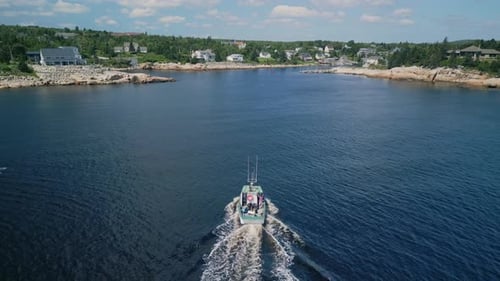 Aerial View A Fishing Motor Boat Sails Into a Bay with a Port in Small Village