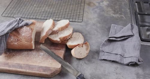 Close up of sliced bread on cutting board in kitchen, slow motion