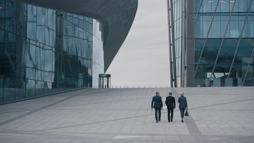 Entrepreneurs Walking across City Square with Glass Architecture
