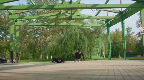Athletic Men Doing Push-Ups in a Public Park