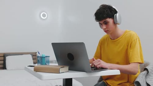 Student Studying At Home With Laptop and Notebook