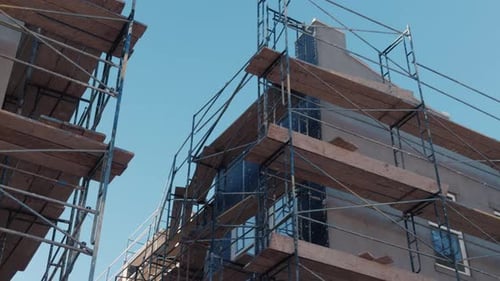 De izquierda a derecha, deslízate más allá de los andamios en el exterior de un edificio residencial sin terminar