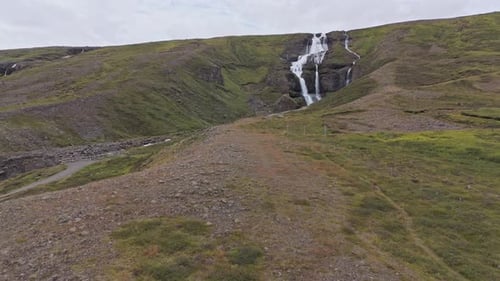 Waterfall In The Mountains Of Iceland With Volcanic Glacier Aerial View