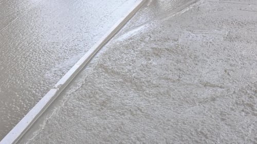 The Concrete Was Poured on of a Wet Cement Sidewalk By a Construction Worker to Level the Concrete