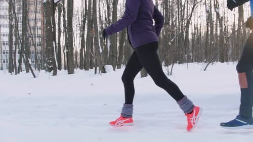 Young Man and Woman Running in Winter Forest Early Morning