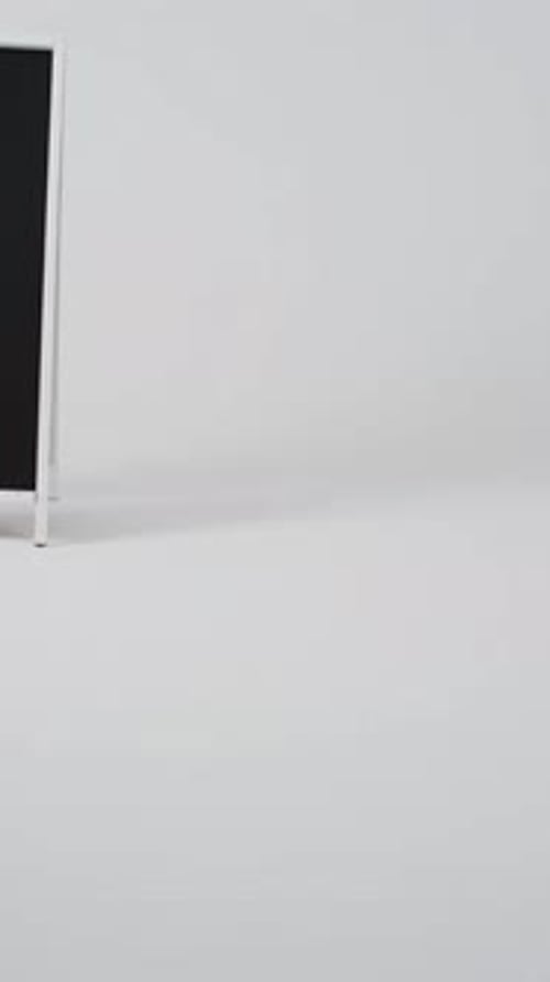 Vertikales Video eines Tafelschilds auf weißem Ständer mit Kopierraum auf weißem Hintergrund