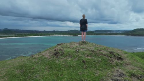 Female Explorer Pauses At Scenic Viewpoint Of Ocean Landscape