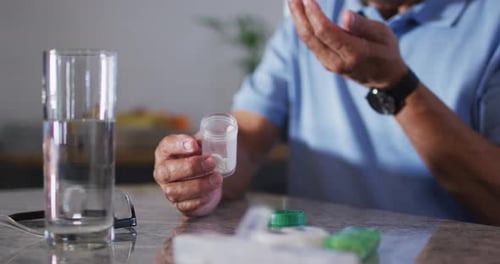 Senior Man Taking Medication with Water Indoors